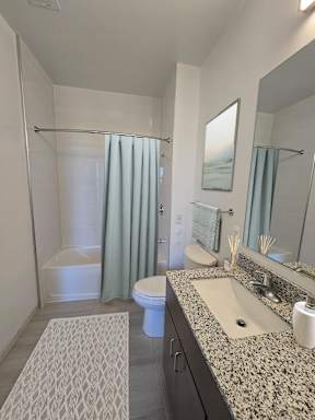A bathroom with a sink, toilet, and shower.
