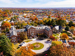 A large building with a circular driveway in front of it.
