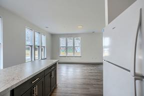 A kitchen with a white fridge and black cabinets.
