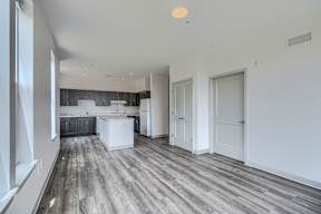 A spacious kitchen with white cabinets and a large island.