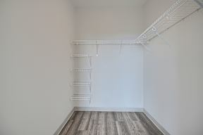 Empty room with white walls and a wooden floor.