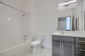 A white bathroom with a toilet, sink, and bathtub.