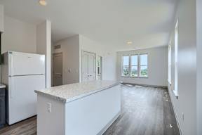A kitchen with white appliances and cabinets is shown.