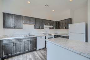 A kitchen with dark wood cabinets and white appliances.