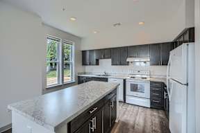 A kitchen with a marble countertop and stainless steel appliances.
