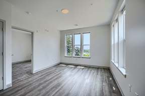 A large empty room with wooden floors and white walls.