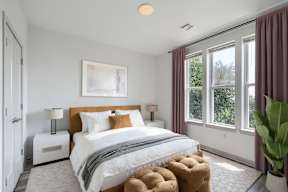 A bedroom with a large bed and a painting on the wall.