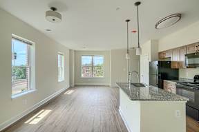 A kitchen with a granite countertop and wooden flooring.