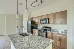 A kitchen with granite countertops and wooden cabinets.