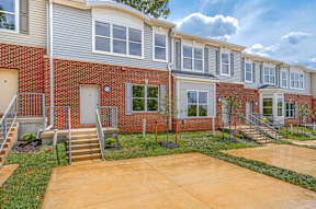 A row of townhouses with a brick facade and white trim.