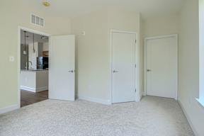 A room with three white doors and a carpeted floor.