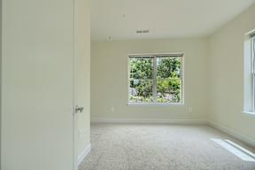 A room with a carpeted floor and a window.