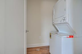 A white oven with a door open in a room with a white wall.