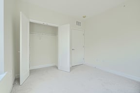 A white room with a door and a closet.