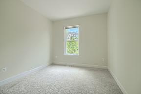 A room with a window showing greenery outside.