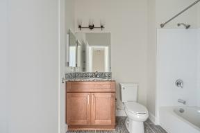 A bathroom with a toilet, sink, and mirror.