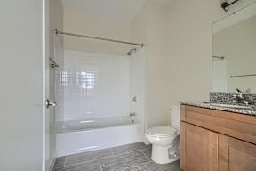 A white toilet sits next to a bathtub in a bathroom.