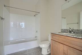 A white bathroom with a tub, toilet and sink.