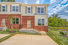 A red brick house with a white door and windows.
