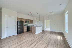 A kitchen with a refrigerator, microwave, and oven.