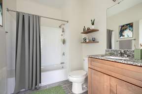 A bathroom with a toilet, sink, and shower curtain.