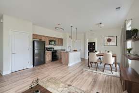A kitchen with a refrigerator, microwave, oven, and sink.