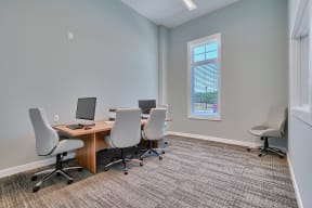 a conference room with a desk and chairs and a window