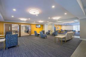 A spacious waiting area with blue patterned chairs and a television.