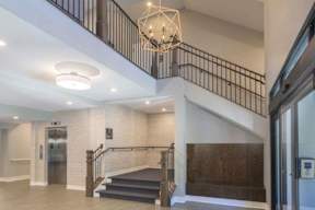A staircase with a metal railing and a glass door.