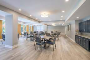 A spacious dining room with a large table and chairs.