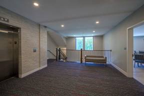 A hallway with a bench and a window.