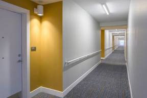 A long hallway with a carpeted floor and white walls.