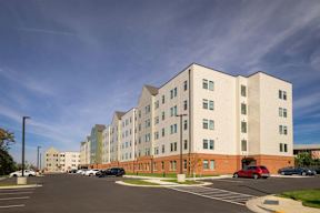 A modern building with a parking lot in front.