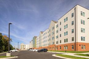 A parking lot in front of a multi-story building.