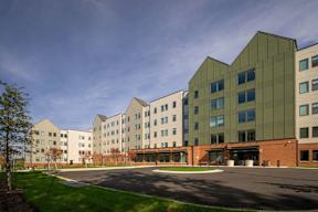 A modern building with a mix of green and beige colored panels.