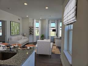 A modern kitchen with a dining area and a living room.