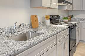 A kitchen with granite countertops and a black oven.