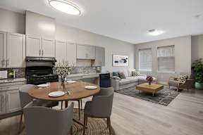 A modern kitchen with a dining table set for two.
