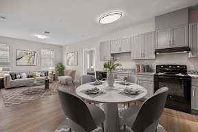 A modern kitchen with a dining table set for two.