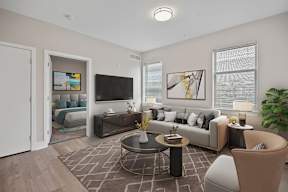 A living room with a grey sofa, a coffee table, and a painting on the wall.