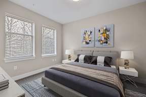 A bedroom with a large bed and two lamps.