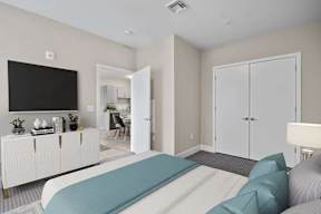 A bedroom with a bed, a television, and a cabinet.