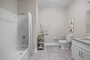 A bathroom with a white tub, toilet, and sink.