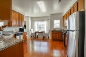 a kitchen and dining room with wood floors and stainless steel appliances