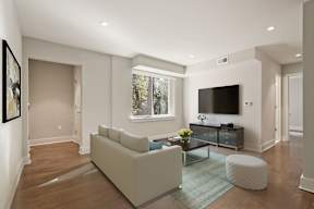 A modern living room with a large couch and a flat screen TV.