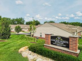 A sign for Cascade Pointe Ranch Homes for Lease stands in front of a building.