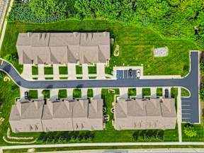 A bird's eye view of a residential area with two buildings and a road.