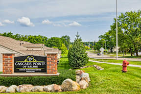 A sign for Cascade Pointe of Saline is in front of a house.