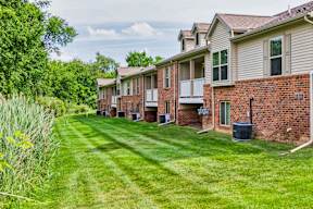 A row of houses with green lawns in front.