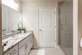 A bathroom with a sink, mirror, and a white door.